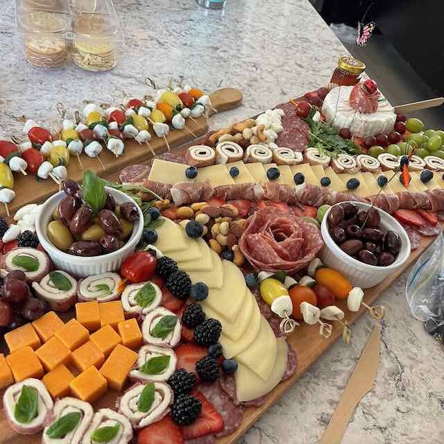 A colorful Delicidad grazing table with cheeses, fruit, and charcuterie
