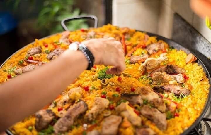 A Delicidad paella being finished by hand